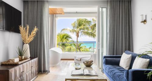 a living room with a blue couch and a view of the ocean at Sandals Royal Barbados All Inclusive - Couples Only in Christ Church