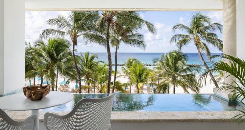 a room with a view of the ocean and palm trees at Sandals Royal Barbados All Inclusive - Couples Only in Christ Church