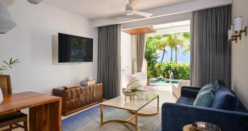 a living room with a blue couch and a table at Sandals Royal Barbados All Inclusive - Couples Only in Christ Church