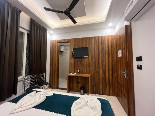 a bedroom with a bed with a ceiling fan at Hotel Vaidik Ganga in Rishīkesh