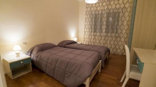 a bedroom with a bed and a table and a window at Le Lune di Diana in Matera