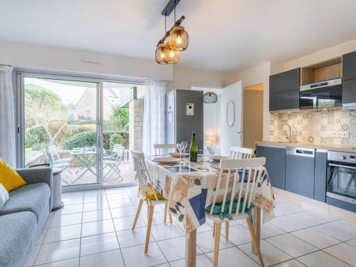 une cuisine et un salon avec une table et des chaises dans l'établissement Carnac : Bel appartement 2 pièces avec terrasse exposée Sud-Est à 500m des plages, parking inclus - FR-1-477-214, à Carnac