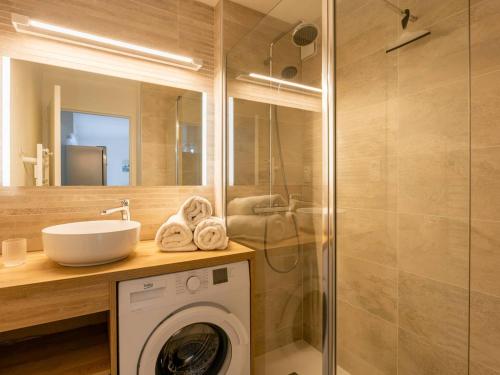 une salle de bain avec une machine à laver et un lavabo dans l'établissement Carnac : Bel appartement 2 pièces avec terrasse exposée Sud-Est à 500m des plages, parking inclus - FR-1-477-214, à Carnac