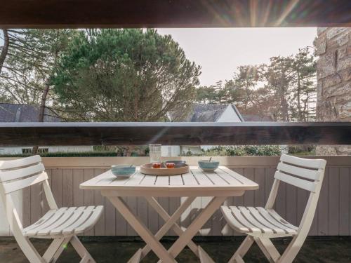 - une table en bois et 2 chaises sur la terrasse dans l'établissement Carnac: Duplex 4p, 3 ch, clim, parking, proche plage - FR-1-477-250, à Carnac