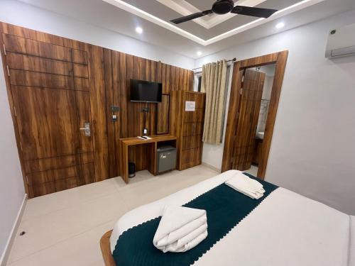 a bedroom with a bed and a tv in it at Hotel Vaidik Ganga in Rishīkesh