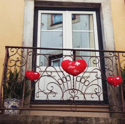 a balcony with red hearts on a window at Castle Inn Lisbon Apartments in Lisbon