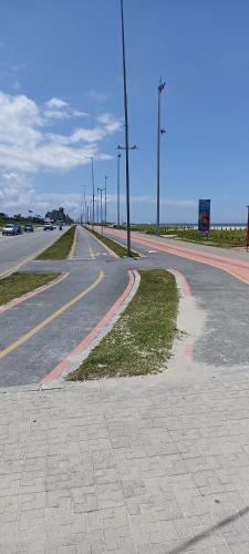 an empty street with a road with cars on it at Aconchegante in Matinhos