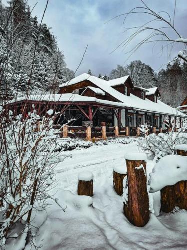 a log cabin in the snow with snow covered trees at Domki w Zacisznej Zagrodzie in Jerzykowice