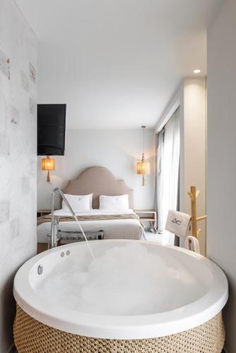 a bathroom with a tub in front of a bed at Blue Carpet Luxury Suites in Pefkohori
