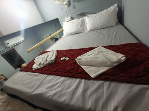 a bed with a red blanket and white pillows at Le Escape Homey in Puducherry