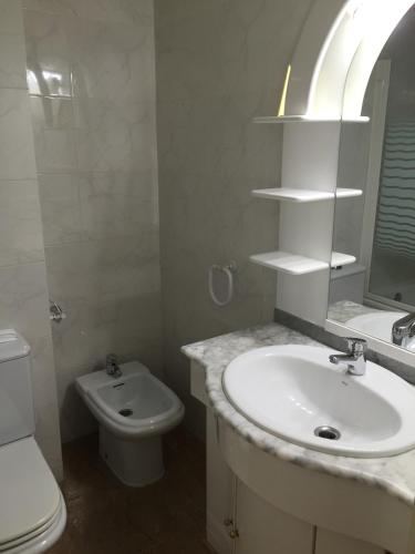 a white bathroom with a sink and a toilet at Apartamento Rosendo in Calafell