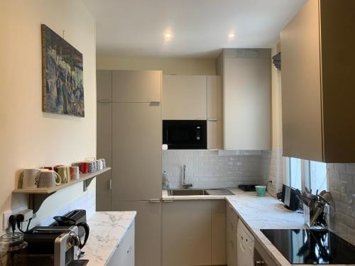 une cuisine avec des armoires blanches et un comptoir dans l'établissement Paris 15, beautiful 3 bedrooms, à Paris