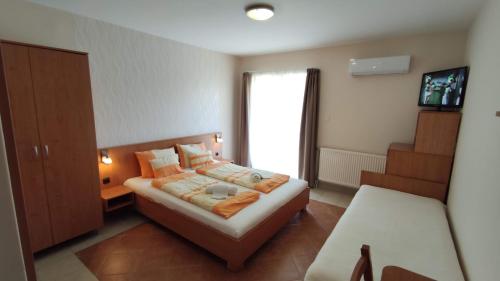 um pequeno quarto com uma cama e uma janela em Zöld Vendégház em Balatonfüred