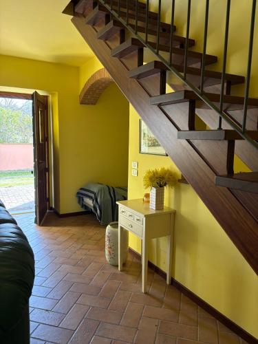 a living room with a wooden staircase and a table at la campagna al mare in Sirolo