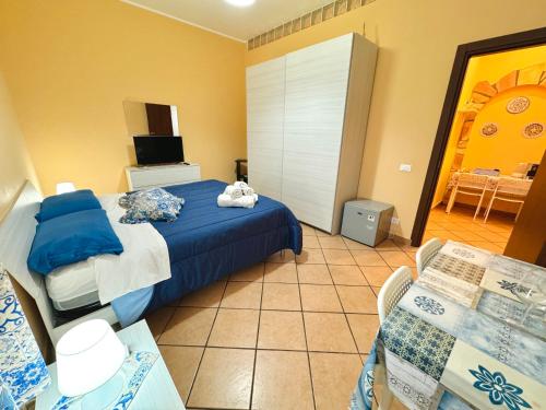 a bedroom with a bed and a table and a tv at Le Maioliche in Sferracavallo