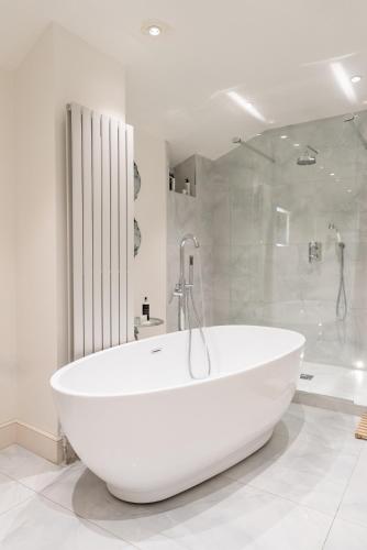 a white bath tub in a bathroom with a shower at Gileston Manor Luxury B&B in Barry