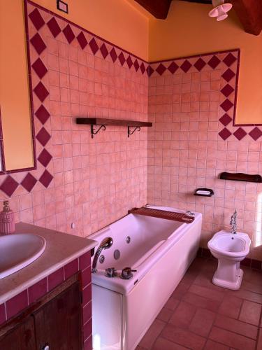 a bathroom with a tub and a toilet and a sink at la campagna al mare in Sirolo