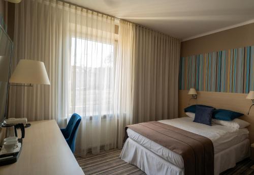 a hotel room with a bed and a window at Hotel Cristal Białystok in Białystok