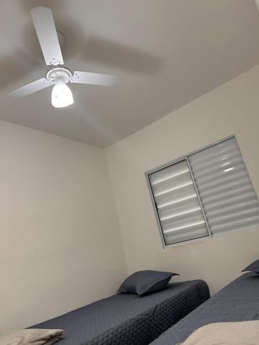 a bedroom with a ceiling fan and a bed at Apto Bela Vista 10 in Pôrto Ferreira