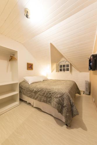 a bedroom with a large bed in a attic at La Vita Pousada de Charme in Campos do Jordão