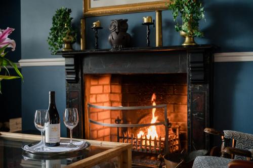 a table with wine glasses and a fireplace at Carrygerry Country House in Shannon