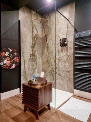 une salle de bain avec douche et table en bois dans l'établissement Love Room La Croix de Saint André, à Saint-André-de-Cubzac