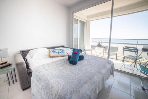 une chambre avec un lit avec un ours en peluche dessus dans l'établissement NEW SANTORINI - INCROYABLE VUE SUR MER - WIFI - GARAGE TopProsConciergerie, à La Grande Motte