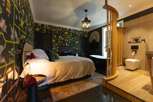 a bedroom with a bed and a bathroom with a tub at Gileston Manor Luxury B&B in Barry