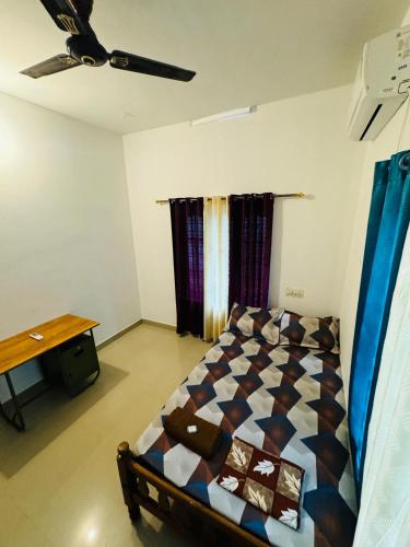 a bedroom with a bed and a table in it at MOON VILLA 01 varkala 3bhk with kitchen in Varkala
