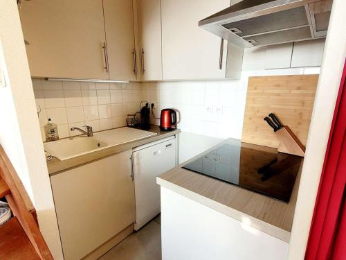 une petite cuisine avec des armoires blanches et un évier dans l'établissement Duplex avec balcon, parking, animaux admis, et Wi-Fi - FR-1-675-2, à Wimereux