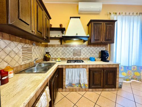 a kitchen with a sink and a stove top oven at Le Maioliche in Sferracavallo