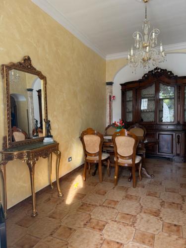 a dining room with a table and a mirror at Voce del Mare Apartment in Pontone