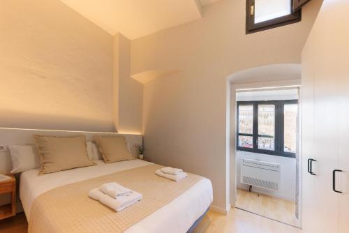 a bedroom with a bed with two towels on it at Bravissimo Calderers La Lleona, heart of the Barri Vell in Girona