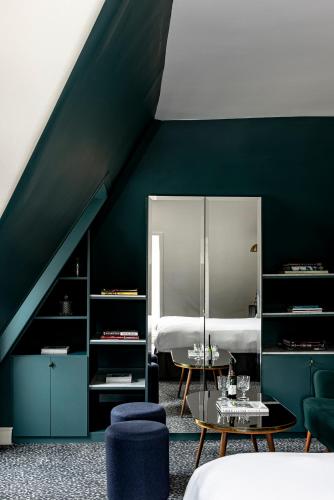 a green room with a bed and a table at Grand Pigalle Experimental in Paris