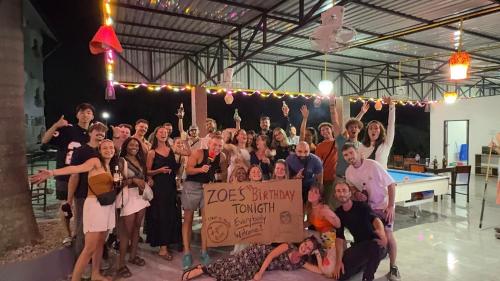a group of people posing for a picture with a sign at Jungle Backpackers View in Vang Vieng