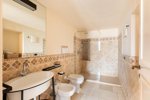 a bathroom with a sink and a toilet and a shower at Masseria Santo Scalone in Ostuni