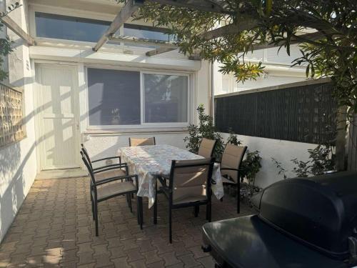 un patio avec une table, des chaises et une fenêtre dans l'établissement Maison 3 pièces, mezzanine, 6 couchages, terrasse, clim, à 80m de la plage - Port-la-Nouvelle - FR-1-229C-88, à Port-la-Nouvelle