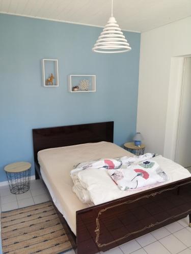 Ce lit se trouve dans une chambre dotée d'un mur bleu. dans l'établissement Maison Ile de Ré, à Sainte-Marie de Ré