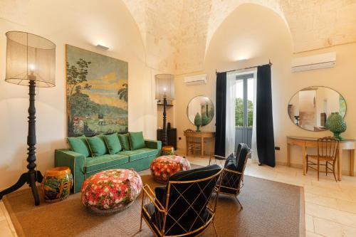 a living room with a green couch and chairs at Masseria Santo Scalone in Ostuni