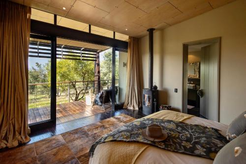une chambre avec un lit et une vue sur une terrasse dans l'établissement Misverstand Boutique Farm Lodge, à Potchefstroom