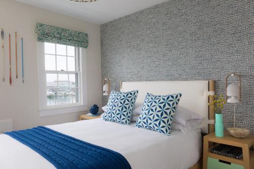 a bedroom with a bed with blue and white pillows at Summercamp in Oak Bluffs