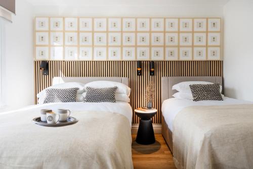 two beds in a hotel room with a tray of mugs at Newly Designed, 2br Apt, 5min from Northwood London Tube Station, NATO HQ, Ideal for Wembley, Warner Studio, Contractors in Northwood
