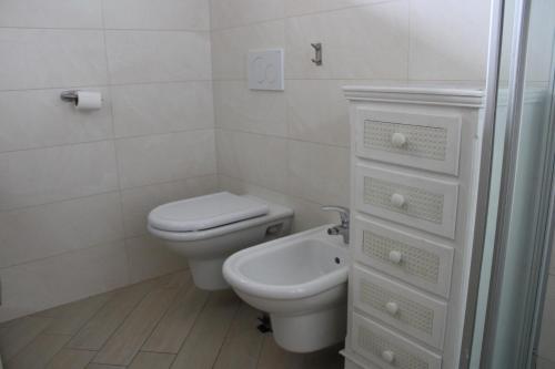 a white bathroom with a toilet and a sink at New Home Lazise in Lazise