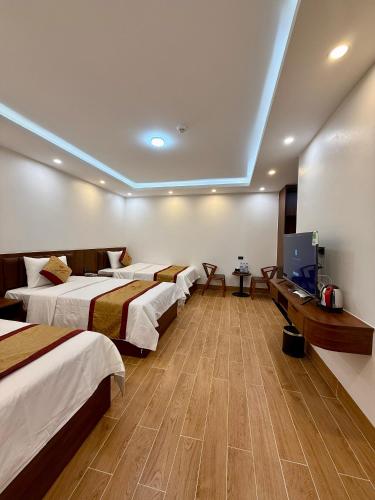 a hotel room with four beds and a flat screen tv at Bảo Ngọc Diamond Hotel 2 in Cao Bằng