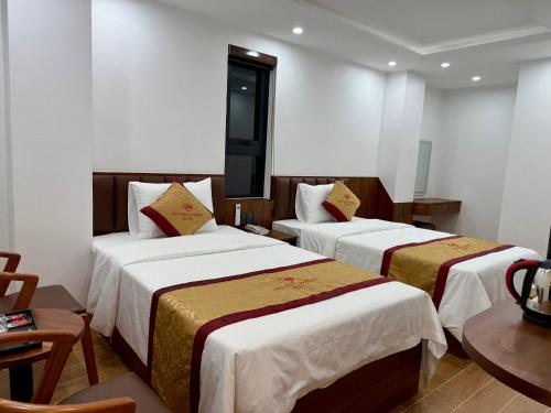 a hotel room with two beds and a table at Bảo Ngọc Diamond Hotel 2 in Cao Bằng
