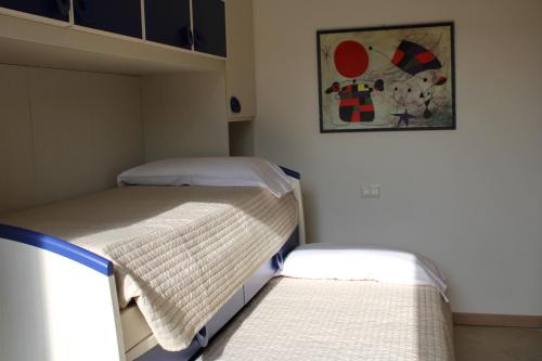 two beds in a small room with a painting on the wall at New Home Lazise in Lazise