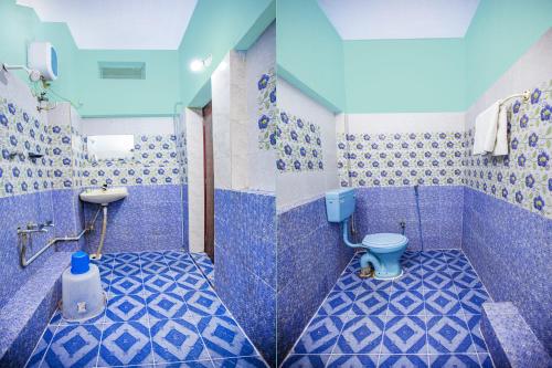 un bagno blu con un water e un lavandino di Doubleonestays Hotel a Pondicherry