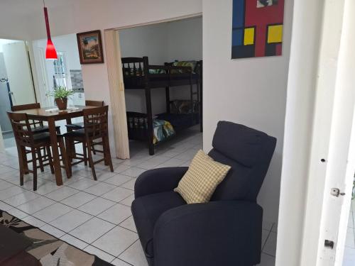 a living room with a blue chair and a table at Tropical Palm Retreat in Willemstad