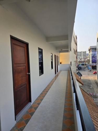 a corridor of a building with a wooden door at Middle tree house pattaya in Pattaya