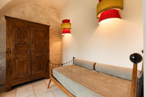 a room with a bench and two lights on the wall at Masseria Santo Scalone in Ostuni